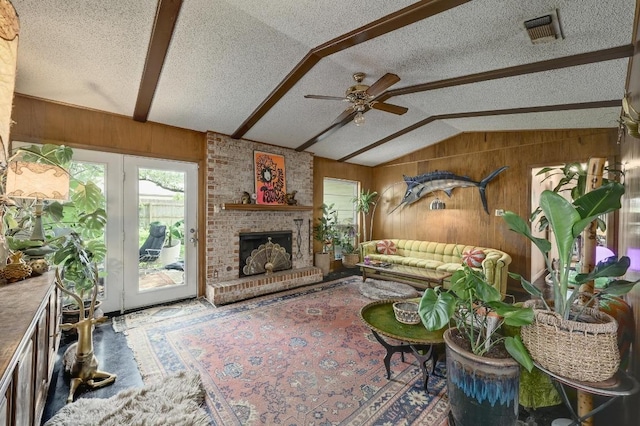 3304 Whitepine Dr, Austin, TX 78757 - living area with a textured ceiling, lofted ceiling, wood walls, ceiling fan, and a fireplace
