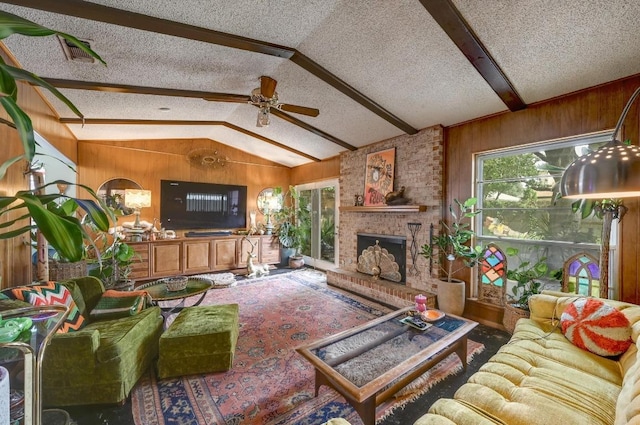 3304 Whitepine Dr, Austin, TX 78757 - living area featuring wood walls, ceiling fan, a fireplace, a textured ceiling, and carpet floors