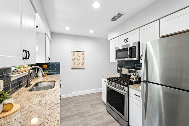 1804 Matthews Ln Unit B, Austin, TX 78745 - kitchen featuring stainless steel appliances, tasteful backsplash, recessed lighting, light stone countertops, and white cabinets