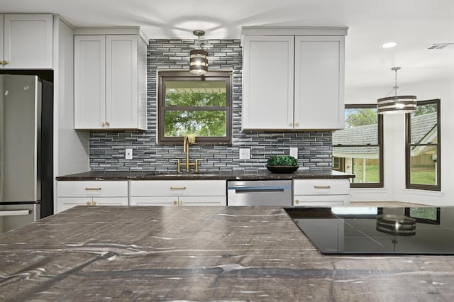 322 Mesa Oaks, Leander, TX 78641 - kitchen with a sink, appliances with stainless steel finishes, dark stone countertops, backsplash, and pendant lighting
