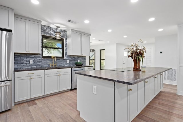 322 Mesa Oaks, Leander, TX 78641 - kitchen featuring a sink, stainless steel appliances, dark countertops, light wood-style flooring, and recessed lighting