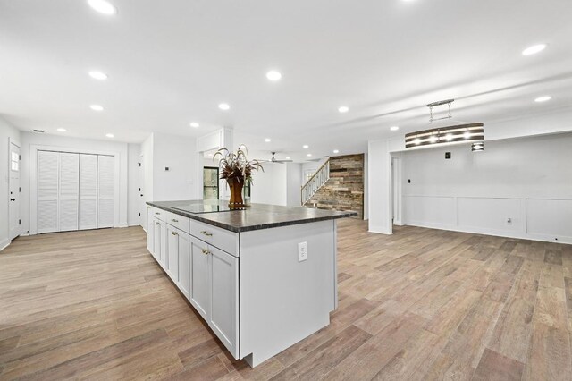 322 Mesa Oaks, Leander, TX 78641 - kitchen featuring light wood-style flooring, a kitchen island, dark countertops, recessed lighting, and open floor plan