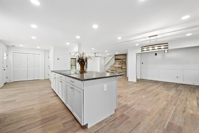 322 Mesa Oaks, Leander, TX 78641 - kitchen with light wood-style flooring, a center island, dark countertops, recessed lighting, and open floor plan