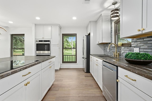 322 Mesa Oaks, Leander, TX 78641 - kitchen featuring a sink, appliances with stainless steel finishes, light wood finished floors, tasteful backsplash, and white cabinets