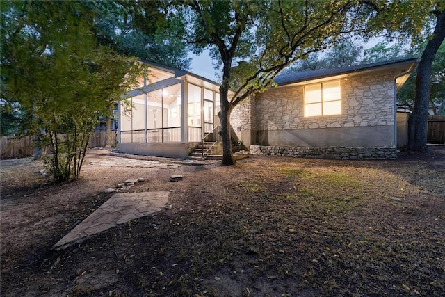 9803 Talleyran Dr, Austin, TX 78750 - rear view of property with stone siding and a sunroom
