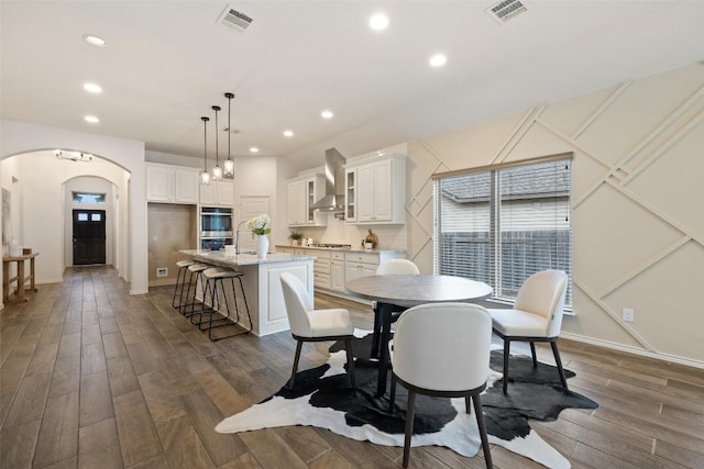400 Saturnia Dr, Georgetown, TX 78613 - dining space with arched walkways, recessed lighting, dark wood-style floors, and baseboards