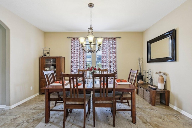 1312 Ravensbrook Bnd, Cedar Park, TX 78613 - dining space featuring a chandelier, baseboards, arched walkways, and stone finish flooring