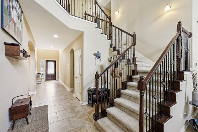 1312 Ravensbrook Bnd, Cedar Park, TX 78613 - tiled entrance foyer featuring arched walkways, a towering ceiling, stairway, baseboards, and recessed lighting
