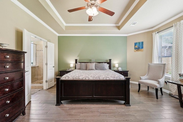 1312 Ravensbrook Bnd, Cedar Park, TX 78613 - bedroom with a tray ceiling, light wood-style floors, crown molding, ceiling fan, and connected bathroom