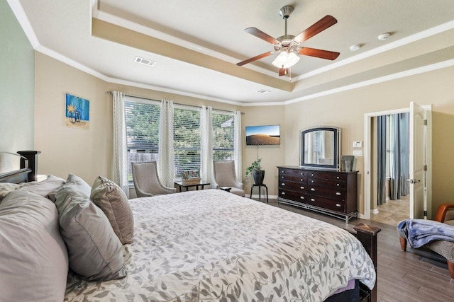 1312 Ravensbrook Bnd, Cedar Park, TX 78613 - bedroom with a tray ceiling, ornamental molding, wood finished floors, ceiling fan, and baseboards