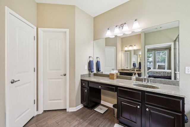 1312 Ravensbrook Bnd, Cedar Park, TX 78613 - ensuite bathroom featuring wood finished floors, vanity, and baseboards
