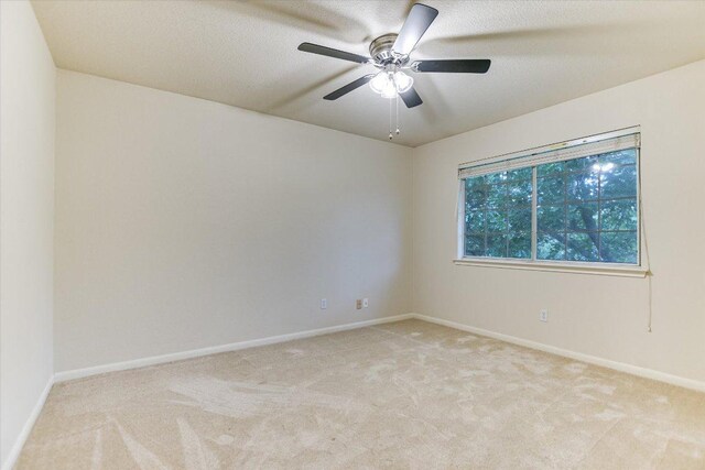 13022 Hunters Chase Dr, Austin, TX 78729 - unfurnished room with light carpet, baseboards, a ceiling fan, and a textured ceiling