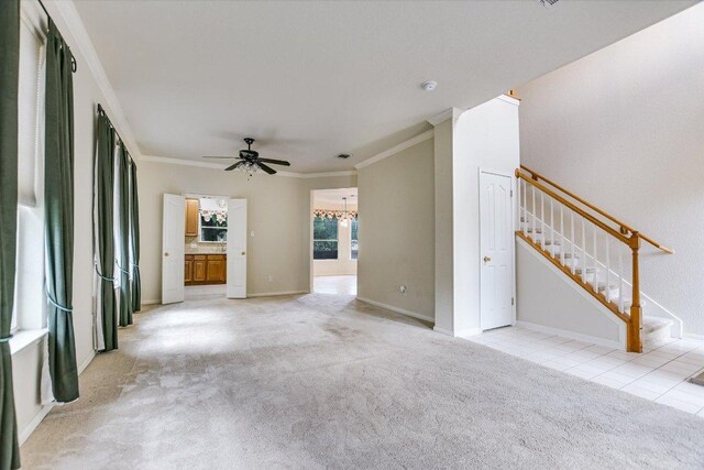 13022 Hunters Chase Dr, Austin, TX 78729 - unfurnished living room with crown molding, ceiling fan, light colored carpet, a chandelier, and stairs