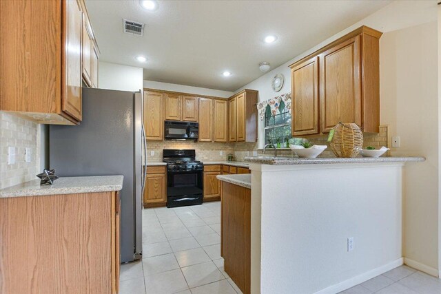 13022 Hunters Chase Dr, Austin, TX 78729 - kitchen with black appliances, tasteful backsplash, light tile patterned flooring, a peninsula, and recessed lighting