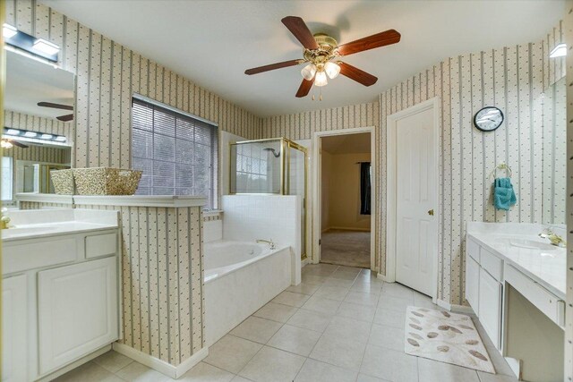 13022 Hunters Chase Dr, Austin, TX 78729 - full bathroom featuring wallpapered walls, a ceiling fan, two vanities, a shower stall, and a garden tub