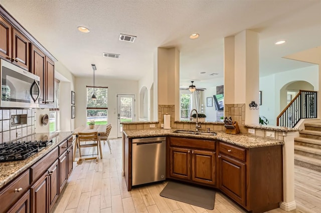 2835 Checker Dr, Cedar Park, TX 78613 - kitchen featuring appliances with stainless steel finishes, tasteful backsplash, light stone countertops, a ceiling fan, and recessed lighting