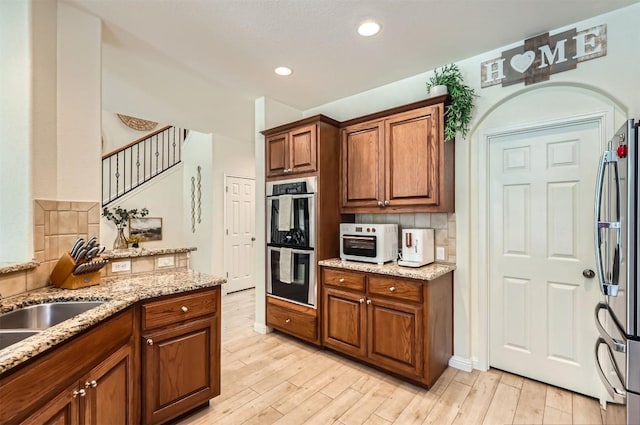2835 Checker Dr, Cedar Park, TX 78613 - kitchen with stainless steel appliances, backsplash, light wood-style floors, light stone countertops, and recessed lighting