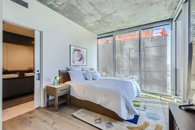 48 E Ave Unit 1210, Austin, TX 78701 - bedroom with multiple windows, a wall of windows, and ensuite bathroom