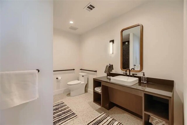 48 E Ave Unit 1210, Austin, TX 78701 - bathroom with toilet, speckled floor, vanity, and baseboards
