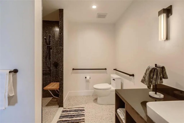 48 E Ave Unit 1210, Austin, TX 78701 - bathroom featuring toilet, baseboards, walk in shower, vanity, and speckle patterned floor
