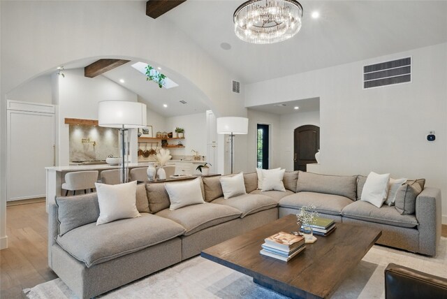12203 Trailmaster Dr, Austin, TX 78737 - living area featuring arched walkways, beamed ceiling, high vaulted ceiling, light wood-style flooring, and a chandelier