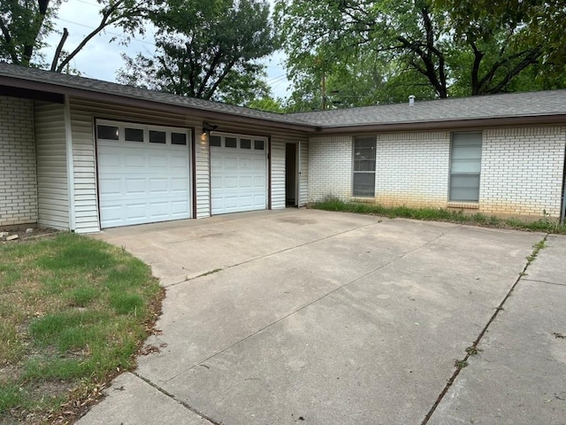 620 Amesbury Ln, Austin, TX 78752 - view of front facade featuring brick siding, an attached garage, driveway, and a shingled roof