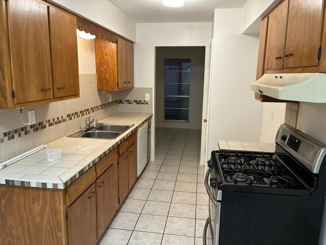 620 Amesbury Ln, Austin, TX 78752 - kitchen with gas stove, under cabinet range hood, tile countertops, a sink, and dishwasher