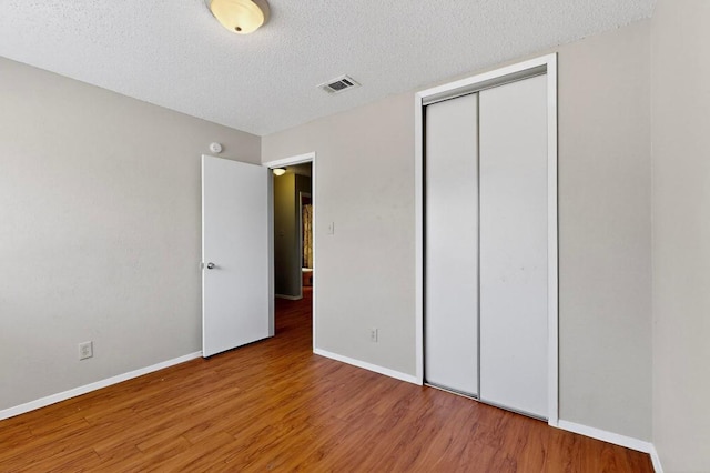 2508 Dovemeadow Dr, Austin, TX 78744 - unfurnished bedroom featuring wood finished floors, a textured ceiling, and a closet