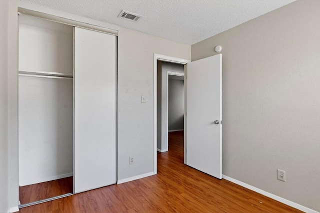 2508 Dovemeadow Dr, Austin, TX 78744 - unfurnished bedroom with wood finished floors, a closet, and a textured ceiling