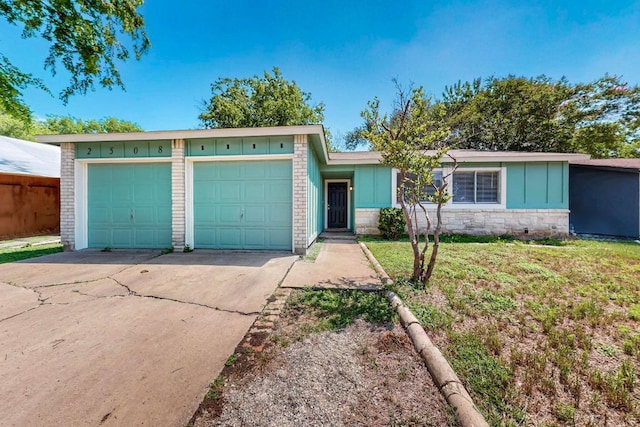 2508 Dovemeadow Dr, Austin, TX 78744 - ranch-style house featuring board and batten siding, concrete driveway, a garage, stone siding, and a front lawn