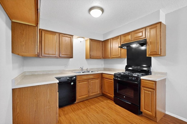 2508 Dovemeadow Dr, Austin, TX 78744 - kitchen featuring black appliances, under cabinet range hood, light wood-style flooring, a textured ceiling, and light countertops