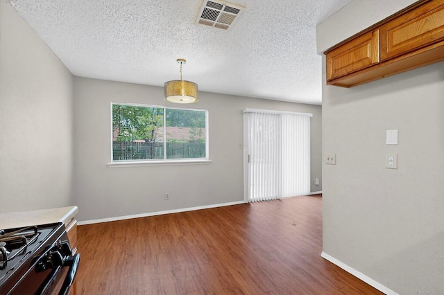 2508 Dovemeadow Dr, Austin, TX 78744 - unfurnished dining area featuring wood finished floors and a textured ceiling