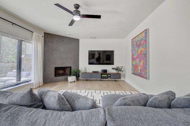 10840 Redmond Rd, Austin, TX 78739 - living room with wood finished floors, a ceiling fan, and a large fireplace