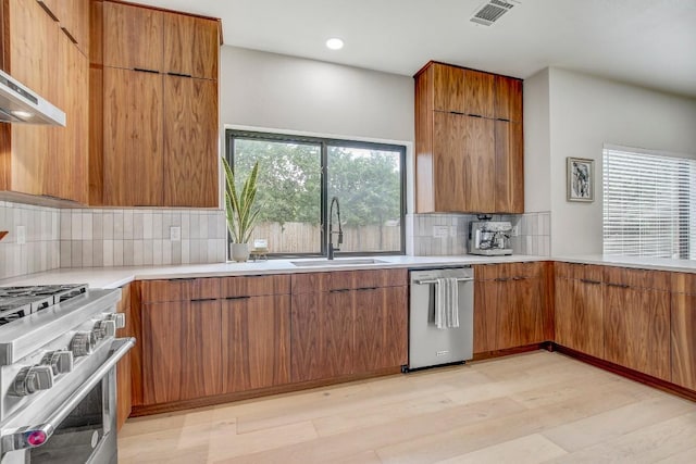 10840 Redmond Rd, Austin, TX 78739 - kitchen featuring a sink, stainless steel appliances, modern cabinets, tasteful backsplash, and light wood-style floors