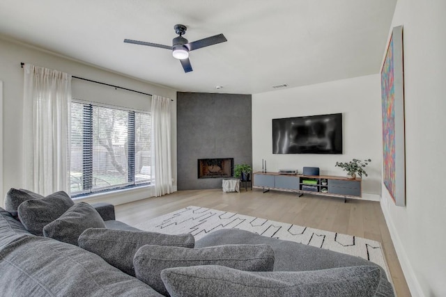 10840 Redmond Rd, Austin, TX 78739 - living room featuring ceiling fan, wood finished floors, a fireplace, and baseboards