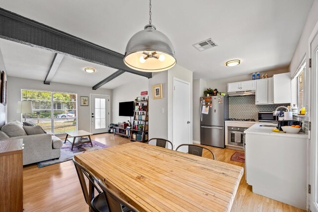 2207 Palmera Cv, Austin, TX 78744 - dining area with light wood-type flooring and beamed ceiling