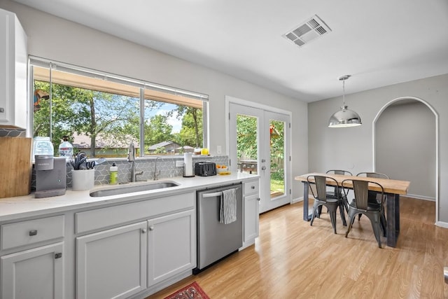 2207 Palmera Cv, Austin, TX 78744 - kitchen featuring dishwasher, a sink, backsplash, light wood finished floors, and plenty of natural light