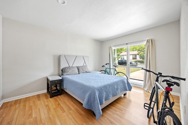 2207 Palmera Cv, Austin, TX 78744 - bedroom with light wood-style floors, baseboards, baseboard heating, and a textured ceiling