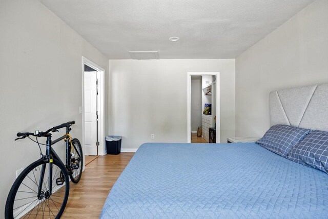 2207 Palmera Cv, Austin, TX 78744 - bedroom with light wood finished floors, attic access, and baseboards