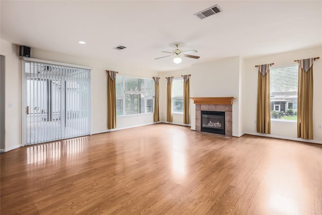 287 Red Poppy Trl, Georgetown, TX 78633 - unfurnished living room featuring ceiling fan, plenty of natural light, wood finished floors, a fireplace, and recessed lighting