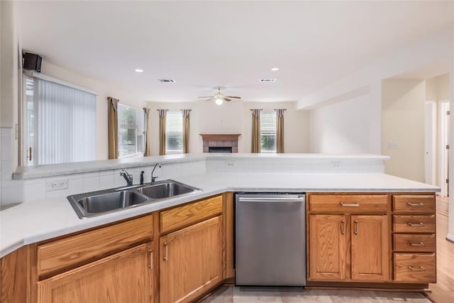 287 Red Poppy Trl, Georgetown, TX 78633 - kitchen featuring dishwasher, ceiling fan, a sink, a tile fireplace, and light countertops