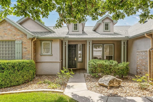 287 Red Poppy Trl, Georgetown, TX 78633 - view of exterior entry with stucco siding, roof with shingles, and stone siding