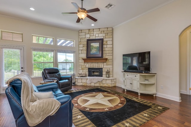 201 Thomas Ridge Rd, Burnet, TX 78611 - living room featuring a stone fireplace, a ceiling fan, crown molding, dark wood-style floors, and plenty of natural light