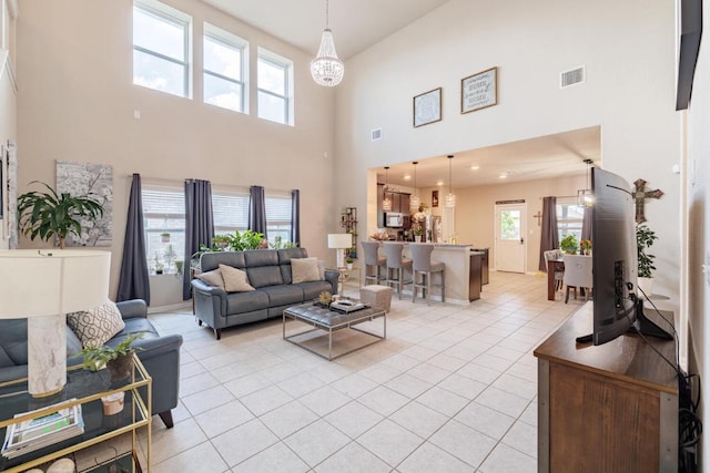 17020 Lathrop Ave, Pflugerville, TX 78660 - living area with a high ceiling, light tile patterned floors, and a chandelier