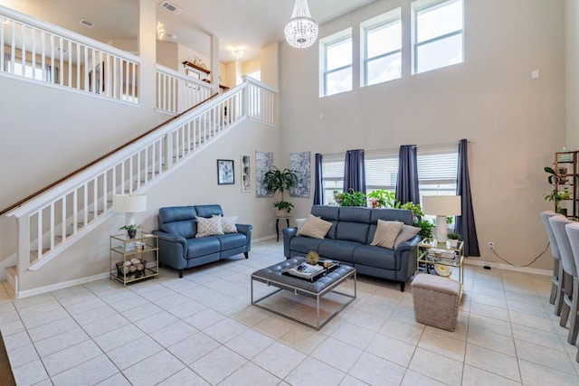 17020 Lathrop Ave, Pflugerville, TX 78660 - living room with a towering ceiling, stairway, light tile patterned flooring, and a chandelier