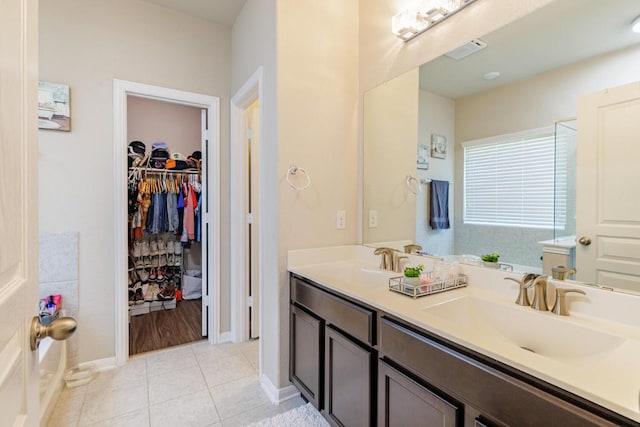 17020 Lathrop Ave, Pflugerville, TX 78660 - bathroom featuring double vanity, tile patterned floors, and a walk in closet