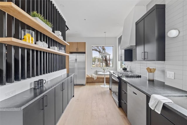 700 Denson Dr Unit 2101, Austin, TX 78752 - kitchen with stainless steel appliances, open shelves, decorative backsplash, dark countertops, and light wood-style floors