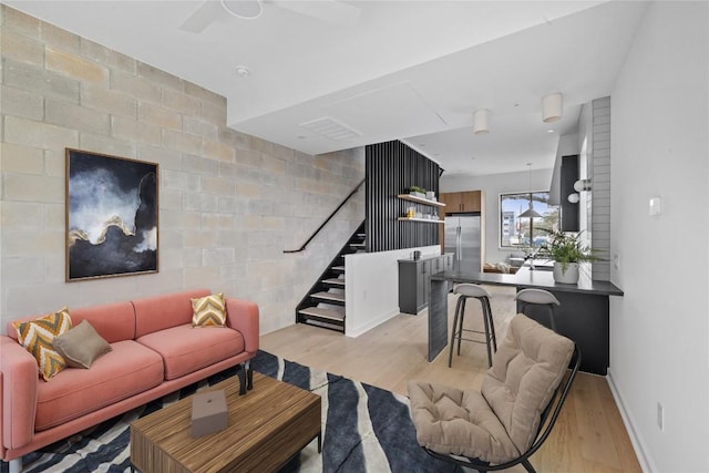 700 Denson Dr Unit 2101, Austin, TX 78752 - living area featuring stairs, light wood-type flooring, baseboards, and a ceiling fan