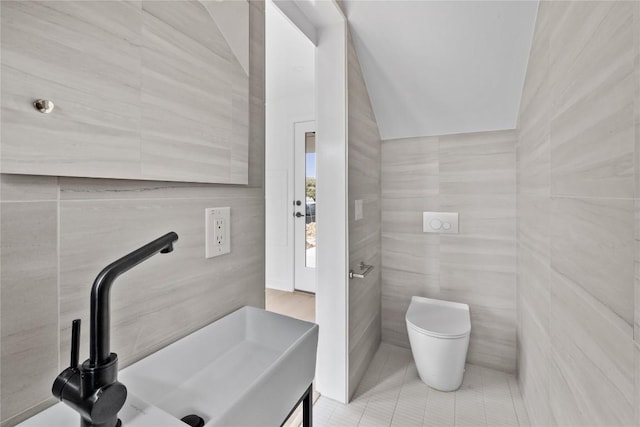 700 Denson Dr Unit 2101, Austin, TX 78752 - bathroom featuring tile walls, a sink, toilet, and tile patterned flooring