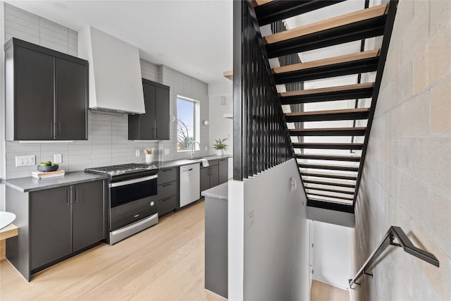 700 Denson Dr Unit 2101, Austin, TX 78752 - kitchen with appliances with stainless steel finishes, custom range hood, light wood-style flooring, open shelves, and a sink